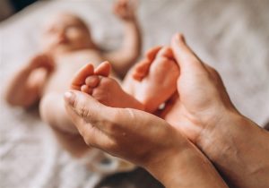 imagens da mãe segurando pés do bebe 